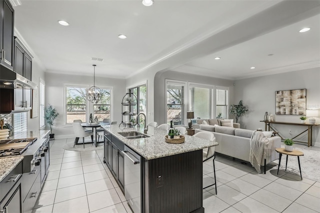 kitchen featuring light tile patterned floors, visible vents, ornamental molding, appliances with stainless steel finishes, and a kitchen bar