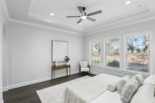 bedroom featuring baseboards, arched walkways, ornamental molding, dark wood-style flooring, and a tray ceiling