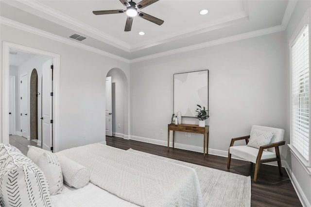 bedroom with arched walkways, a tray ceiling, visible vents, dark wood-type flooring, and baseboards