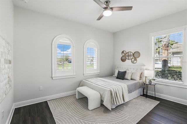 bedroom featuring dark wood-type flooring, ceiling fan, and baseboards