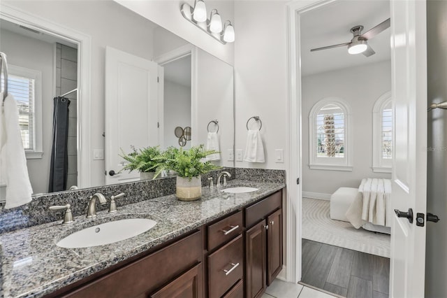 bathroom with double vanity, a sink, and a wealth of natural light