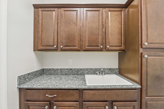 kitchen featuring light stone countertops and a sink