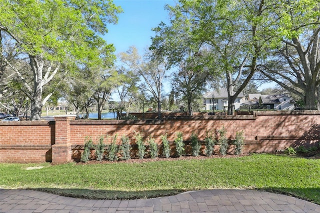 community / neighborhood sign featuring a yard and a water view