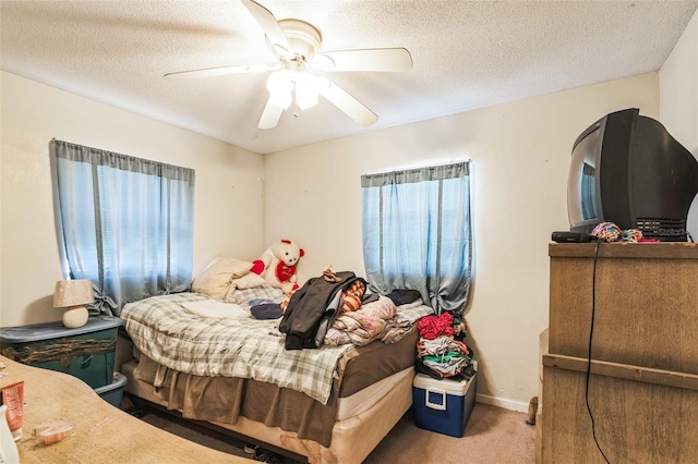 carpeted bedroom featuring baseboards, a textured ceiling, and ceiling fan