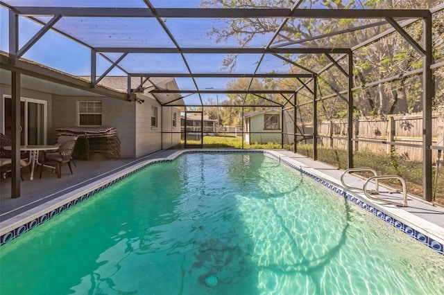 view of pool with a patio area, glass enclosure, a fenced in pool, and fence