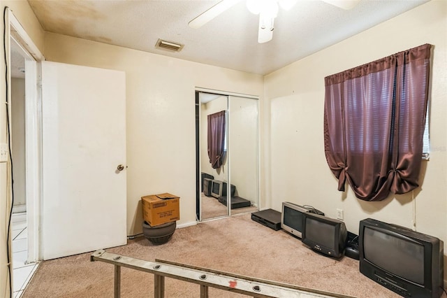 interior space featuring carpet, visible vents, a closet, and ceiling fan