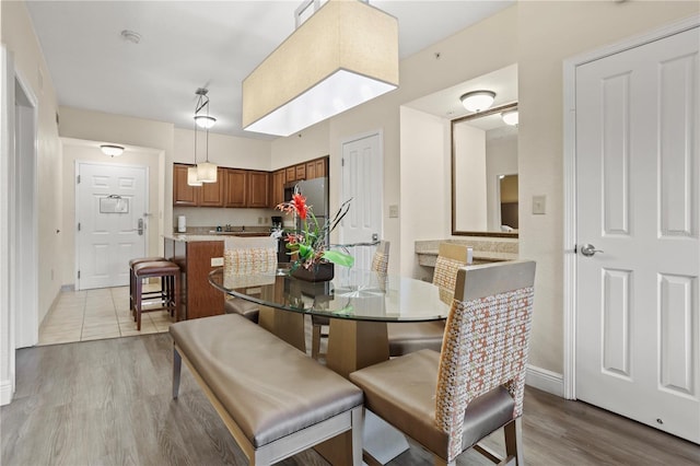 dining room featuring light wood finished floors and baseboards