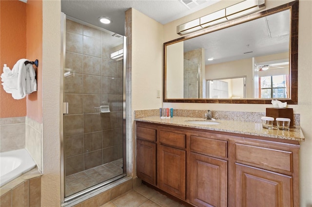 full bathroom with a stall shower, tile patterned flooring, a garden tub, and vanity