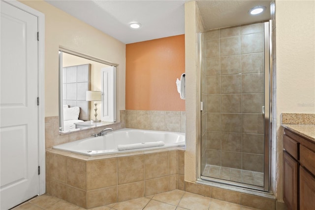 full bath with a stall shower, tile patterned flooring, a bath, and vanity