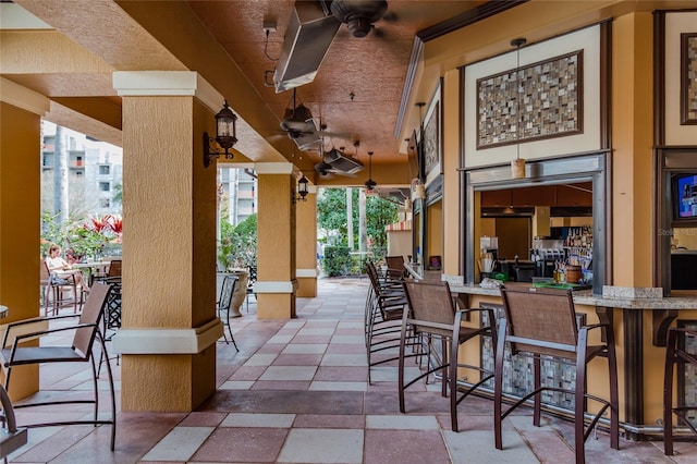 view of patio featuring a bar and a ceiling fan