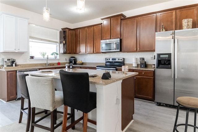 7407 Ripplepointe Way, Windermere, FL 34786 - kitchen featuring stainless steel appliances, light wood-style flooring, a center island with sink, backsplash, and a sink