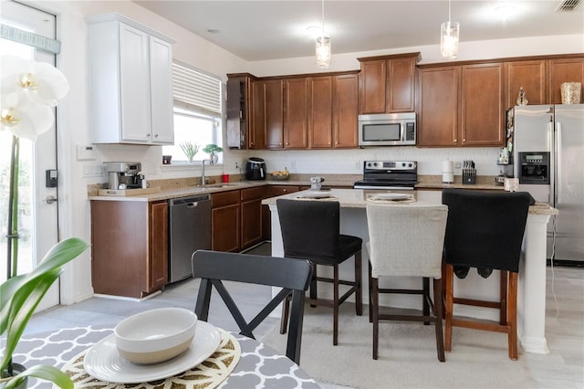 7407 Ripplepointe Way, Windermere, FL 34786 - kitchen featuring stainless steel appliances, a kitchen island, backsplash, light countertops, and a breakfast bar