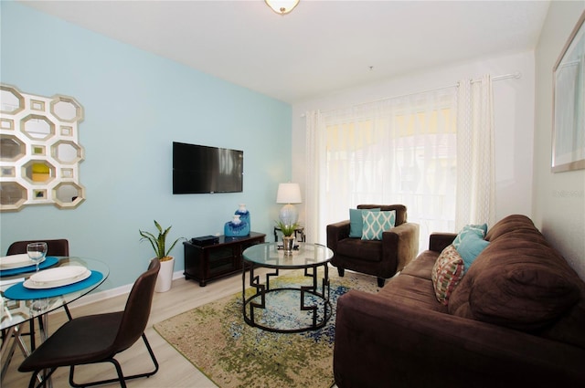 living area with baseboards and wood finished floors