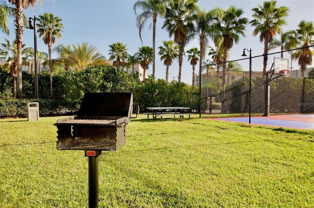 view of home's community with community basketball court, a yard, and fence