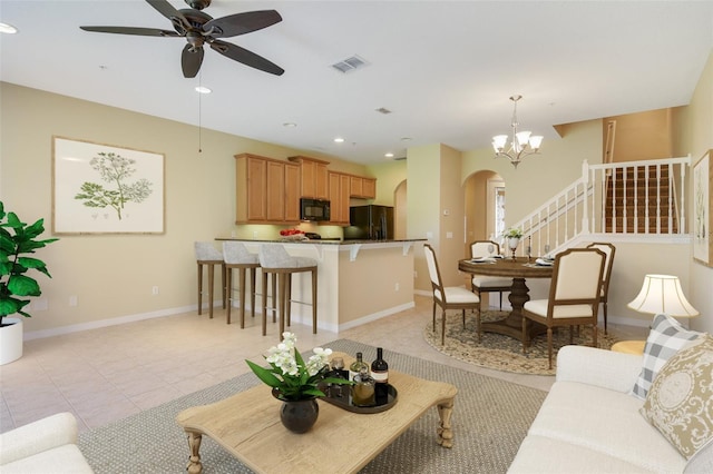 living room with visible vents, stairway, arched walkways, light tile patterned floors, and baseboards