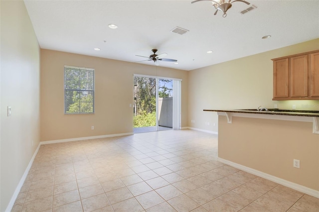 empty room featuring visible vents, baseboards, and ceiling fan