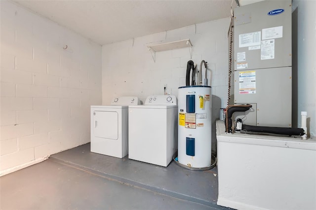 washroom featuring laundry area, water heater, heating unit, washing machine and clothes dryer, and concrete block wall