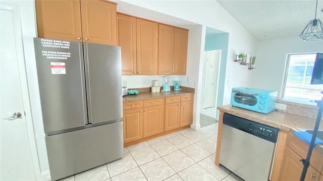 kitchen with light tile patterned floors, stainless steel appliances, vaulted ceiling, hanging light fixtures, and light countertops