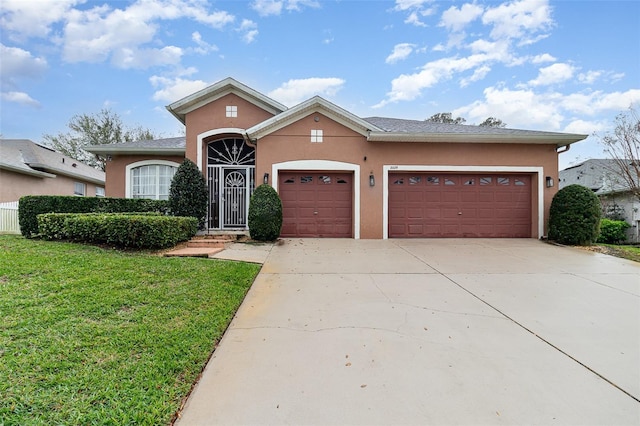 view of front facade featuring stucco siding, a front lawn, an attached garage, and driveway