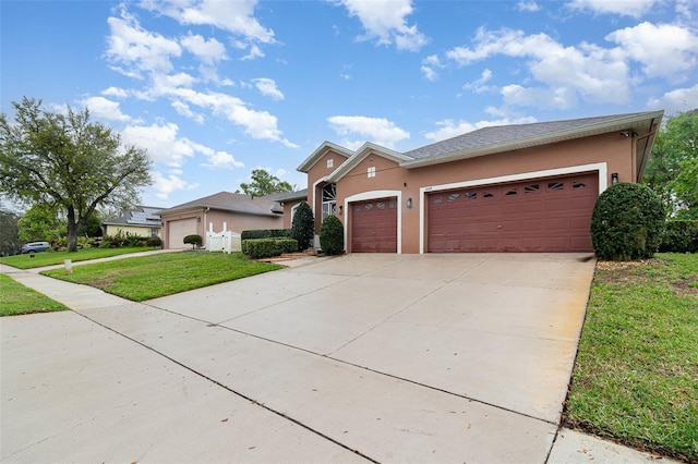 view of front of house featuring a front yard, an attached garage, driveway, and stucco siding