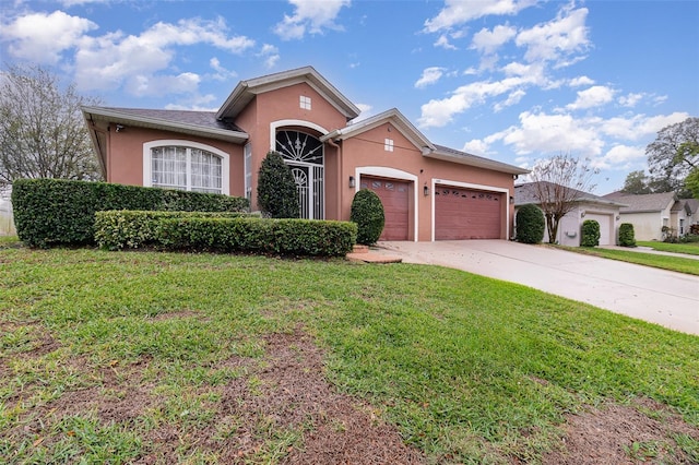 ranch-style house featuring concrete driveway, an attached garage, a front yard, and stucco siding