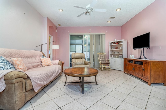 living room with visible vents, light tile patterned floors, a ceiling fan, and arched walkways