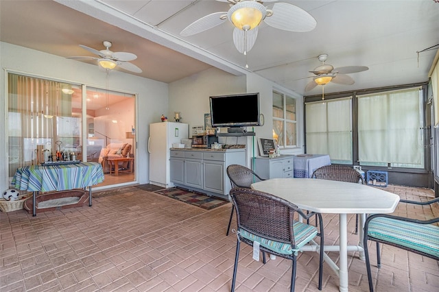 sunroom / solarium with a ceiling fan