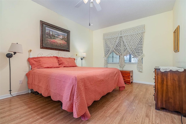 bedroom with baseboards, a textured ceiling, ceiling fan, and light wood finished floors