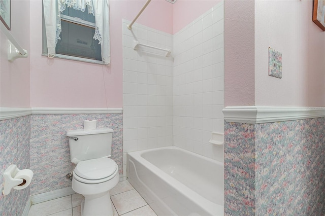 bathroom featuring tile patterned flooring, shower / tub combination, toilet, and a wainscoted wall