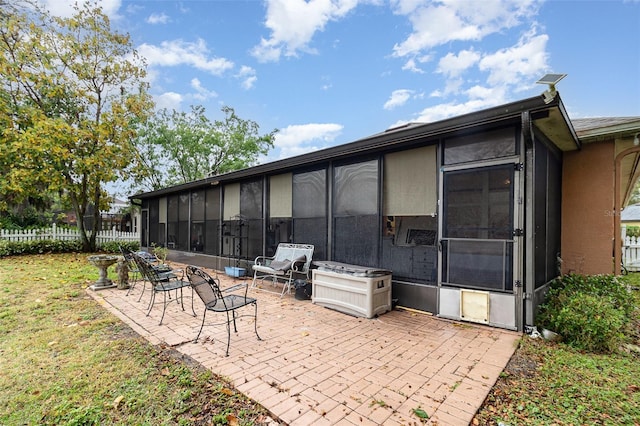 view of patio with fence and a sunroom