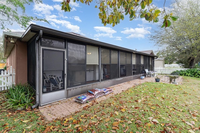 back of house with a yard, fence, and a sunroom