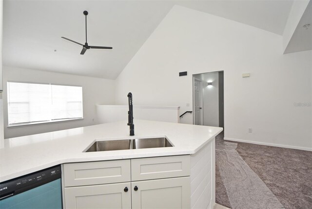 kitchen featuring carpet floors, light countertops, vaulted ceiling, a sink, and dishwashing machine