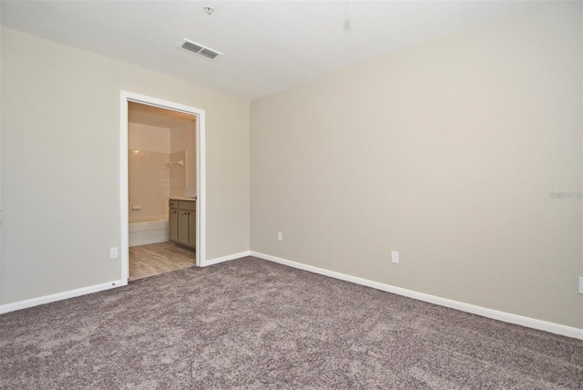 empty room with carpet flooring, visible vents, and baseboards