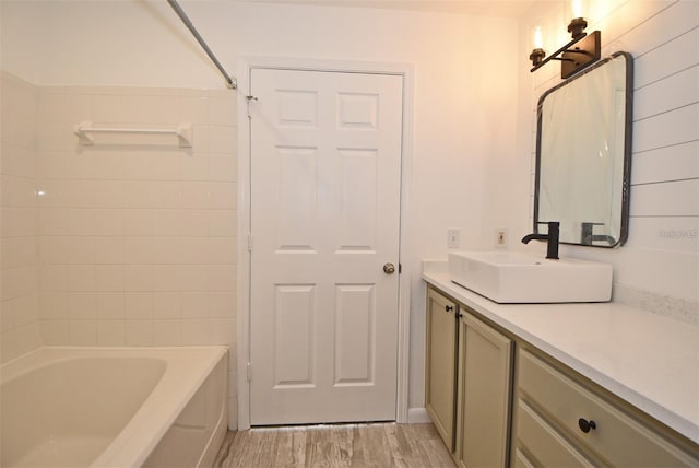 bathroom featuring tub / shower combination, wood finished floors, and vanity