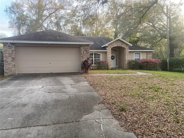 ranch-style house featuring a garage, brick siding, roof with shingles, and driveway