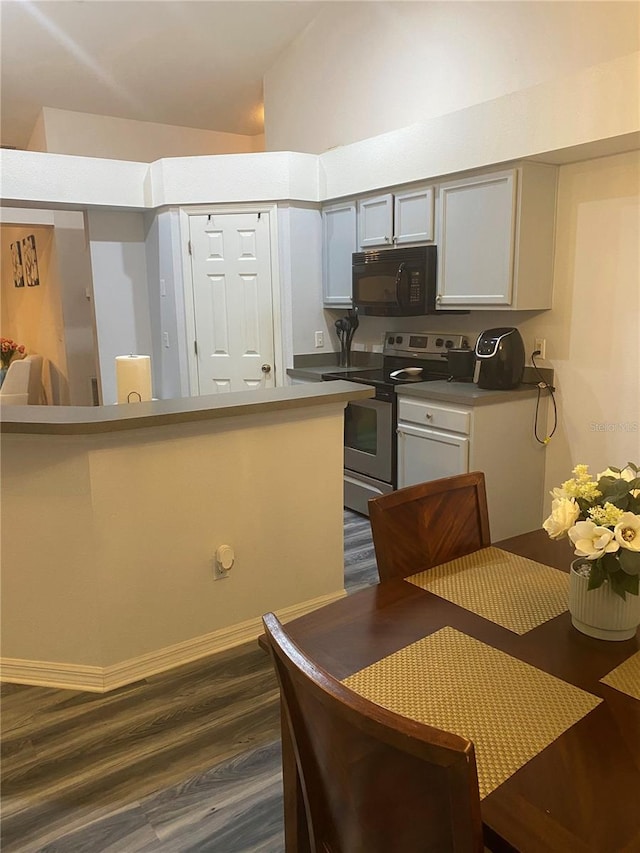 kitchen featuring dark wood-style floors, stainless steel electric range, black microwave, and gray cabinetry