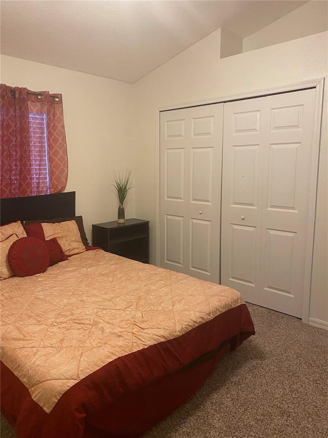 bedroom with a closet, carpet floors, and vaulted ceiling