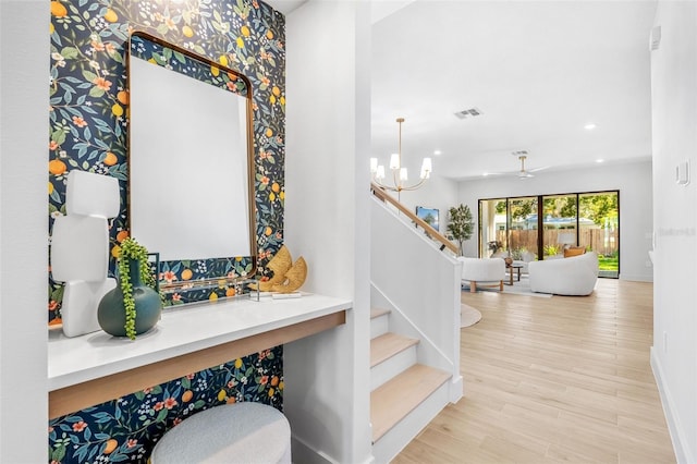 stairs with visible vents, wood finished floors, recessed lighting, baseboards, and a chandelier