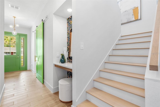 entryway featuring stairway, wood finished floors, visible vents, and baseboards