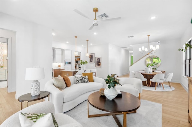 living area with light wood-style flooring, recessed lighting, visible vents, and baseboards