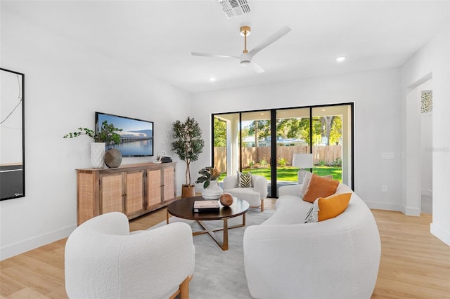 living room featuring visible vents, baseboards, ceiling fan, light wood-type flooring, and recessed lighting