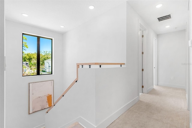 corridor with an upstairs landing, visible vents, carpet flooring, and recessed lighting