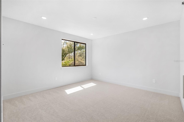 unfurnished room with recessed lighting, light colored carpet, and baseboards