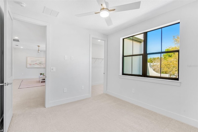 unfurnished bedroom featuring a spacious closet, visible vents, baseboards, and carpet floors