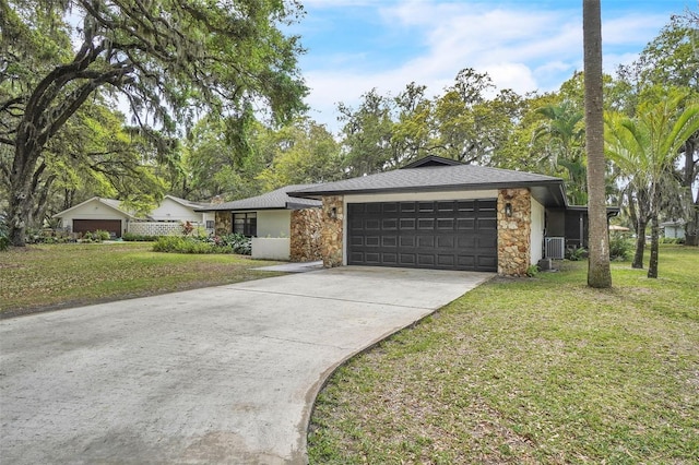 view of front of house with a front yard, stone siding, and central AC