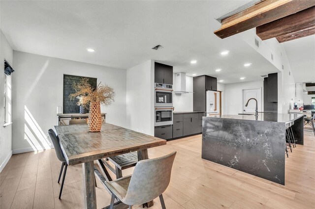 dining area with beam ceiling, recessed lighting, visible vents, and light wood finished floors