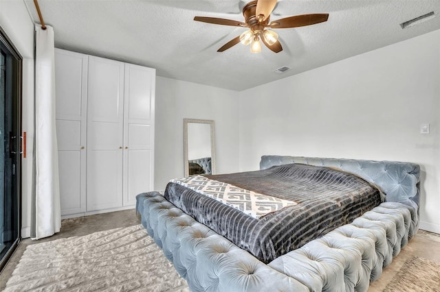 bedroom featuring visible vents, a textured ceiling, and ceiling fan