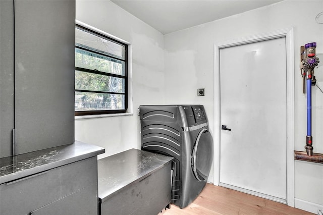 clothes washing area featuring independent washer and dryer, laundry area, and light wood-type flooring