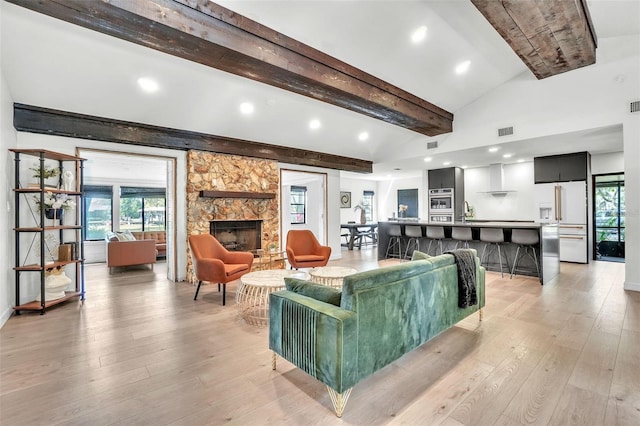 living room featuring a fireplace, light wood-type flooring, plenty of natural light, and recessed lighting