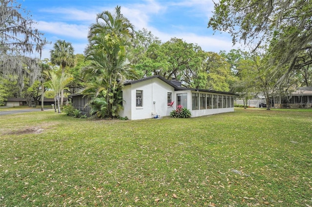 view of grassy yard featuring a sunroom